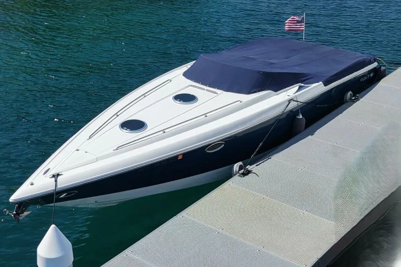  Yacht Photos Pics 2005 Cobalt 343 boat docked with American flag, covered in blue tarp.