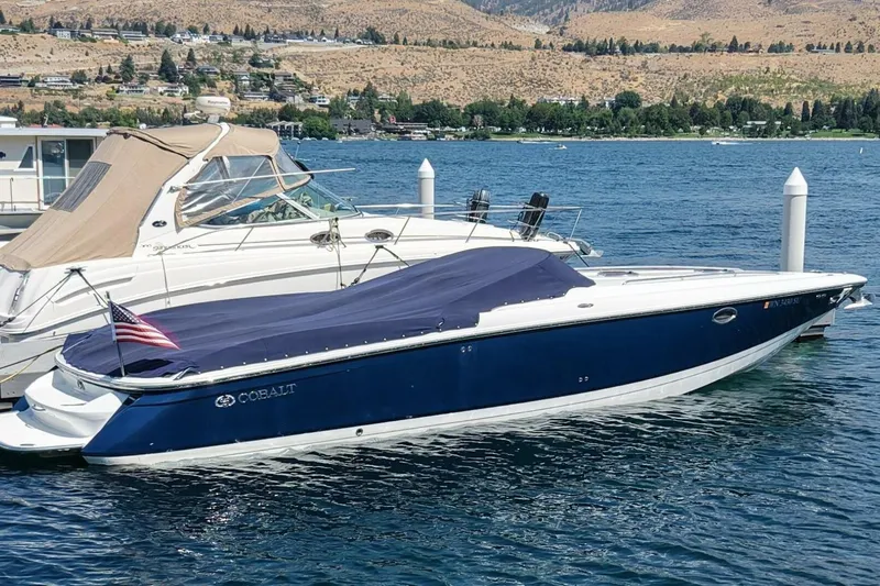  Yacht Photos Pics 2005 Cobalt 343 boat docked on a lake with scenic hillside background.