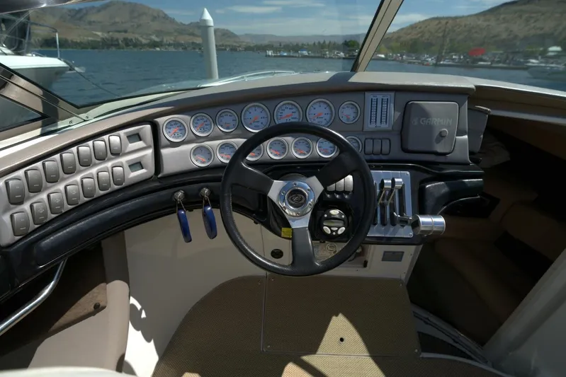  Yacht Photos Pics Cockpit of 2005 Cobalt 343 boat with steering wheel, gauges, and controls on a lake.