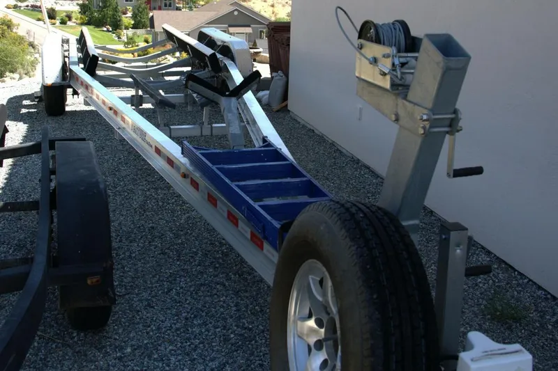  Yacht Photos Pics Boat trailer for 2005 Cobalt 343 on gravel driveway, featuring winch and spare tire.