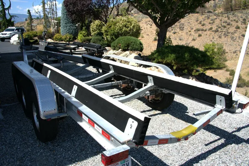  Yacht Photos Pics 2005 Cobalt 343 boat trailer parked on gravel driveway with scenic background.