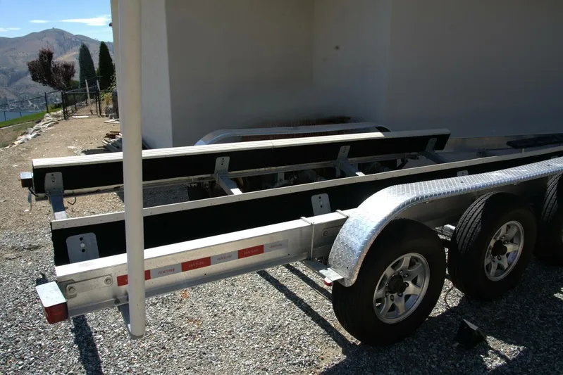 Yacht Photos Pics Boat trailer for 2005 Cobalt 343, parked on gravel near a scenic landscape.