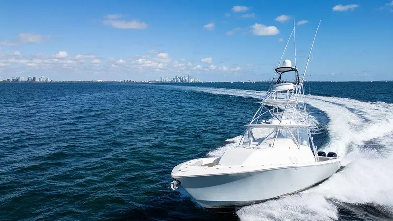  Yacht Photos Pics 2015 SeaVee 430 Fisharound cruising on open water, clear sky, city skyline in background.
