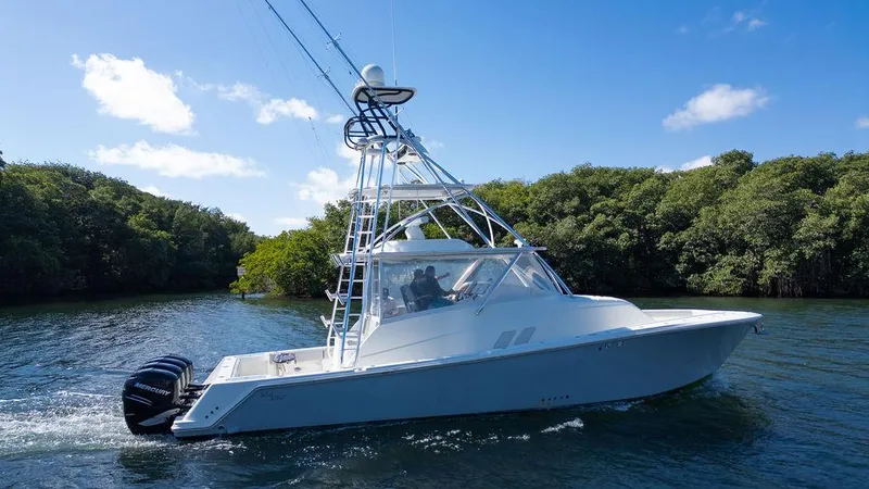  Yacht Photos Pics 2015 SeaVee 430 Fisharound boat cruising on a sunny day, surrounded by lush greenery.