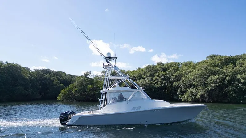  Yacht Photos Pics 2015 SeaVee 430 Fisharound boat cruising on a sunny day near lush greenery.