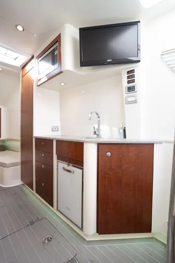 Yacht Photos Pics 2015 SeaVee 430 Fisharound interior with kitchenette, TV, and modern cabinetry.