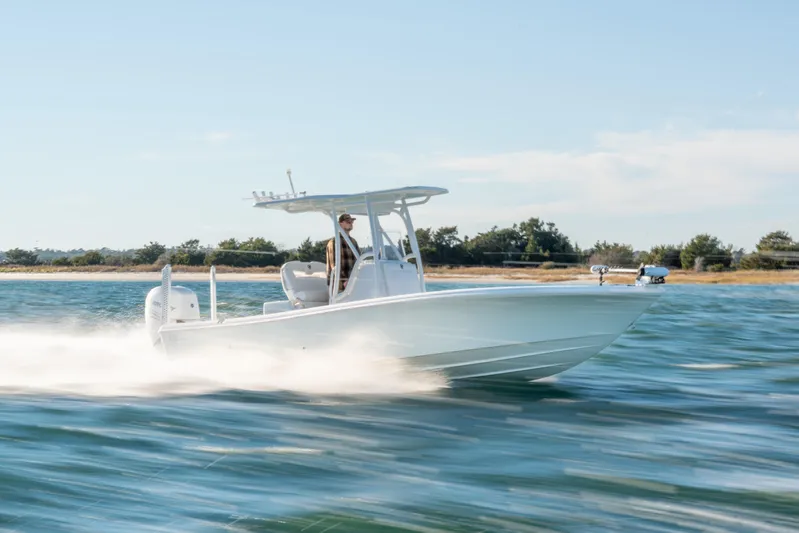  Yacht Photos Pics 2020 BARKER 26 boat speeding on water near a shoreline under a clear sky.