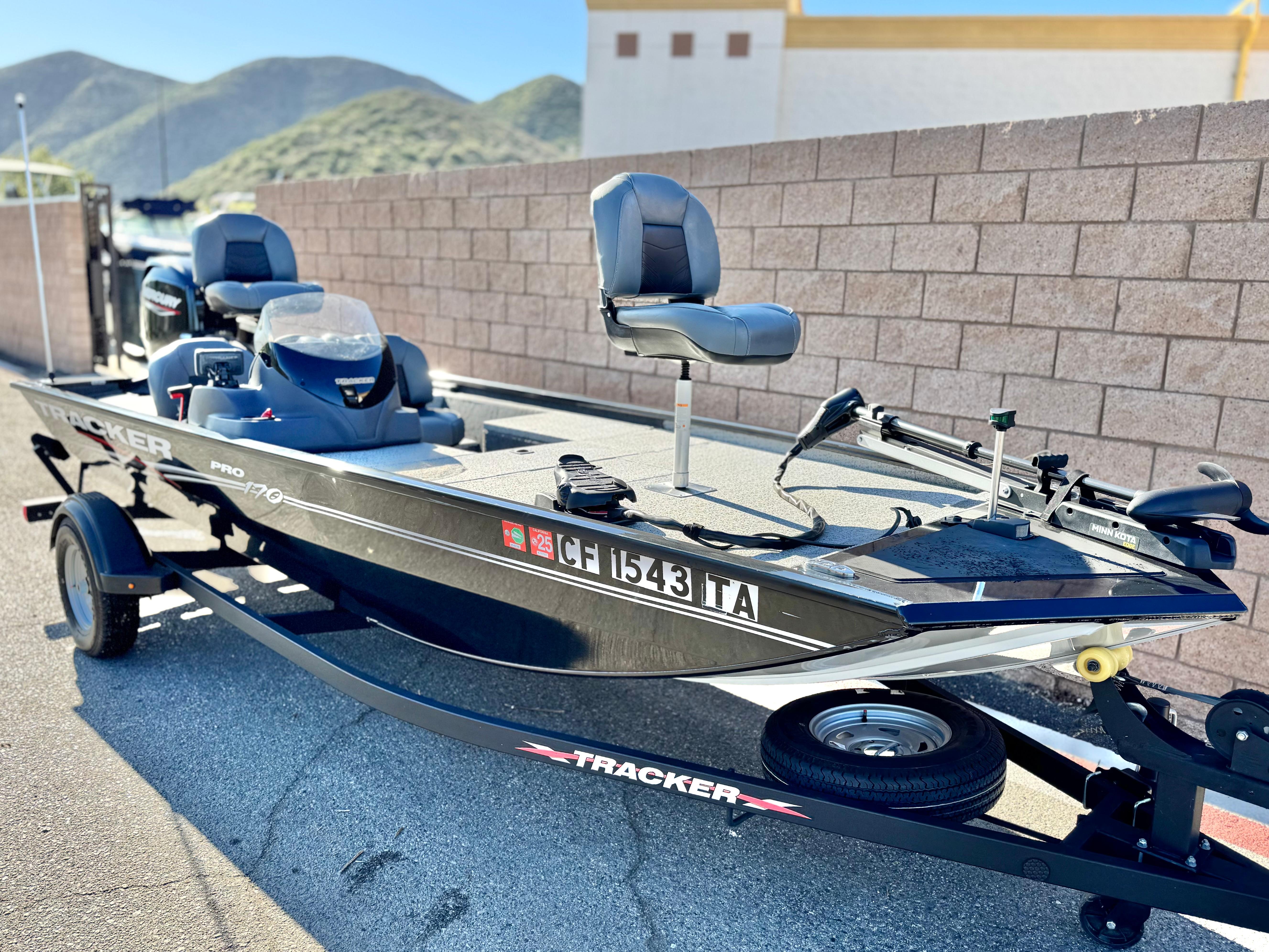 2024 Tracker Pro 170 boat on trailer, parked outdoors with mountains in background.