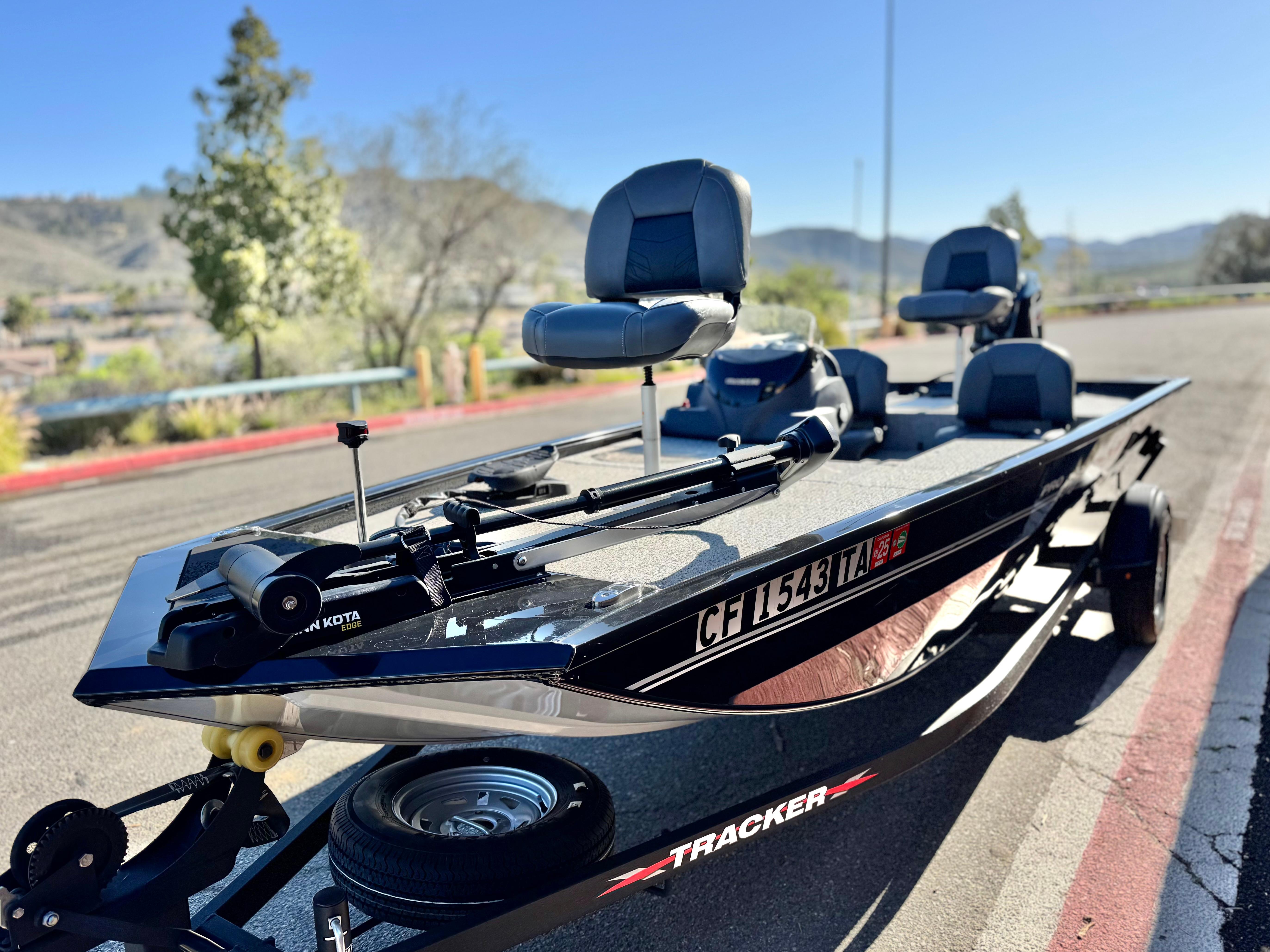 2024 Tracker Pro 170 boat on trailer, parked outdoors with scenic background.