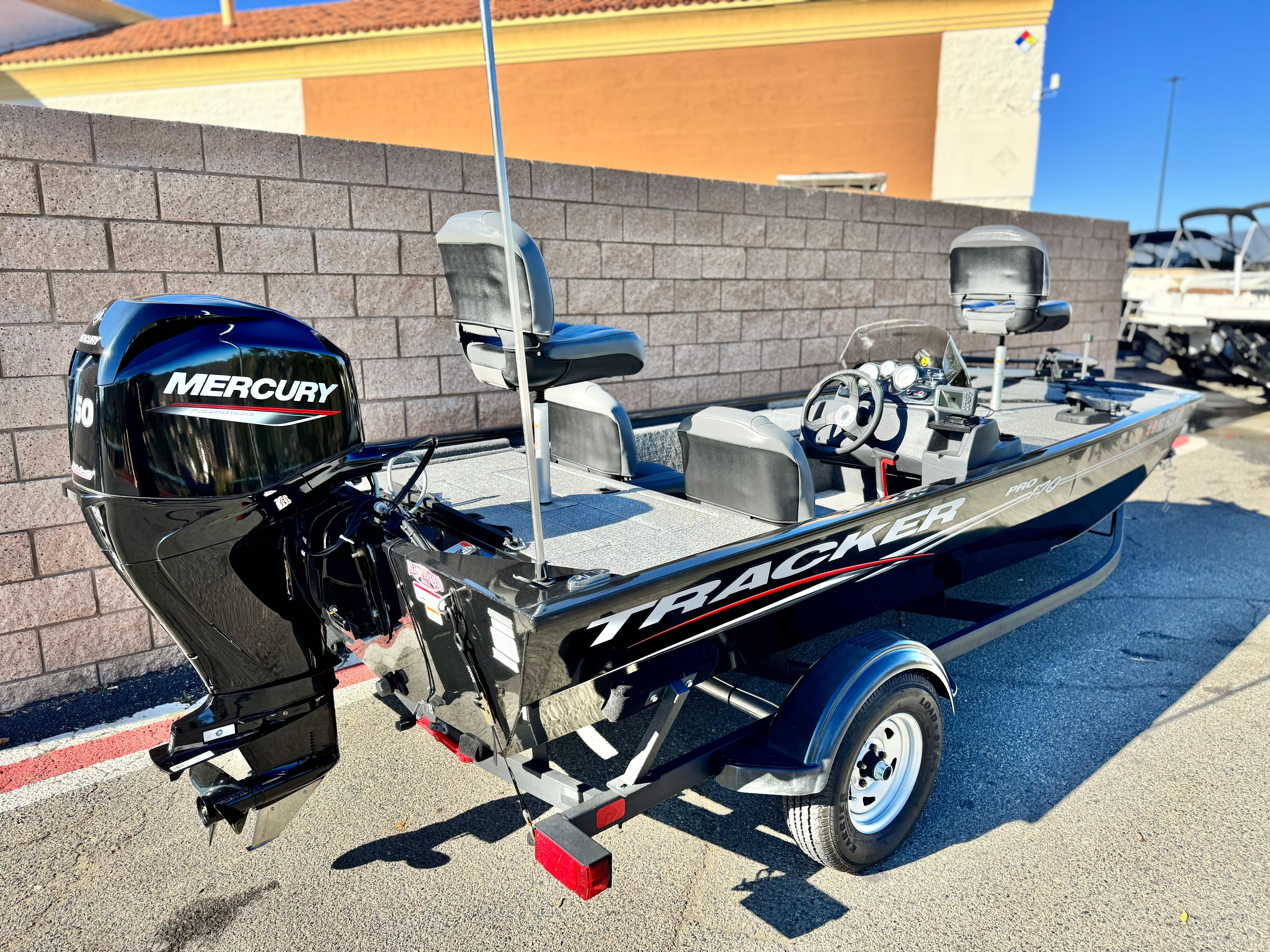 2024 Tracker Pro 170 boat with Mercury engine, parked outdoors, showcasing sleek design and seating.