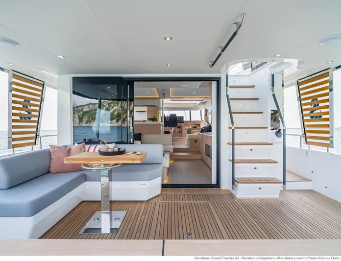  Yacht Photos Pics Luxurious 2025 Beneteau Grand Trawler 62 yacht interior with elegant seating and staircase.