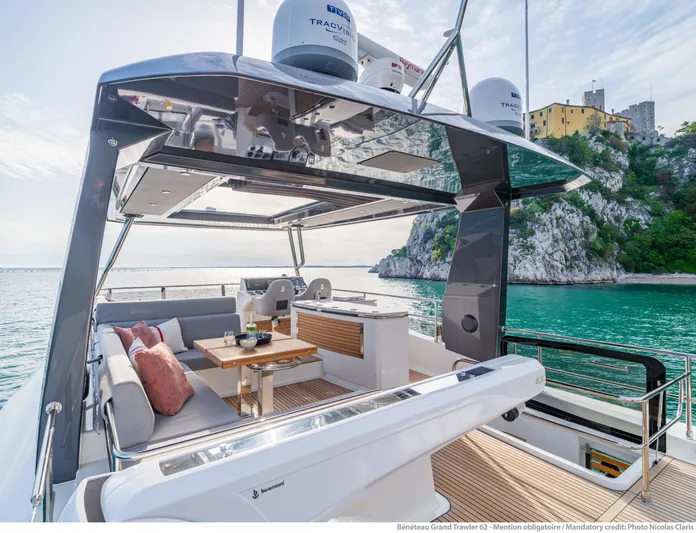  Yacht Photos Pics Luxurious 2025 Beneteau Grand Trawler 62 yacht with elegant outdoor seating and scenic ocean view.