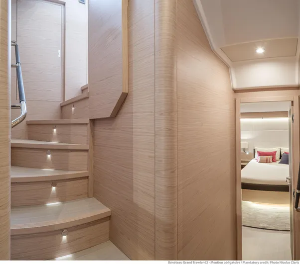  Yacht Photos Pics Interior of 2025 Beneteau Grand Trawler 62, featuring elegant wooden staircase and cozy bedroom.