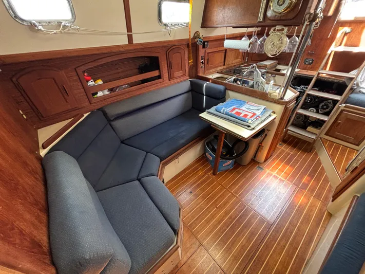 Pacific Seacraft Crealock 37 Yacht Photos Pics Interior of 1995 Pacific Seacraft Crealock 37 sailboat with cozy seating and wooden flooring.