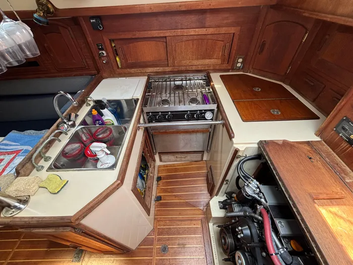 Pacific Seacraft Crealock 37 Yacht Photos Pics Galley of 1995 Pacific Seacraft Crealock 37 with stove, sink, and wooden cabinetry.