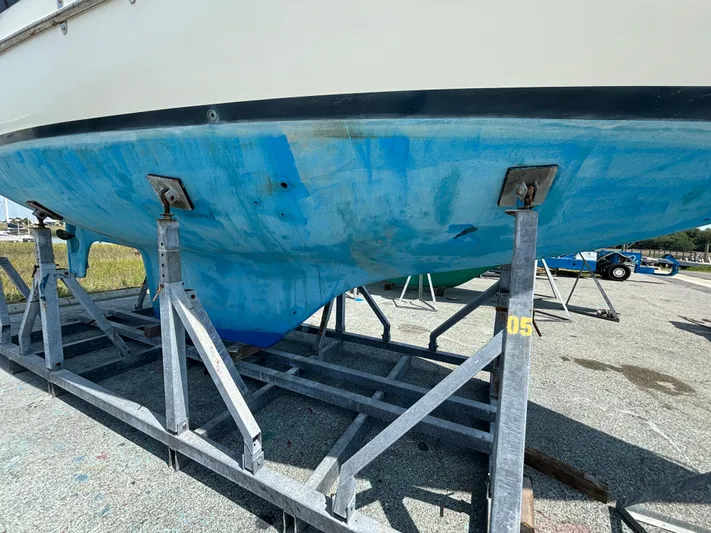 Pacific Seacraft Crealock 37 Yacht Photos Pics 1995 Pacific Seacraft Crealock 37 sailboat hull on metal stands, blue paint visible.