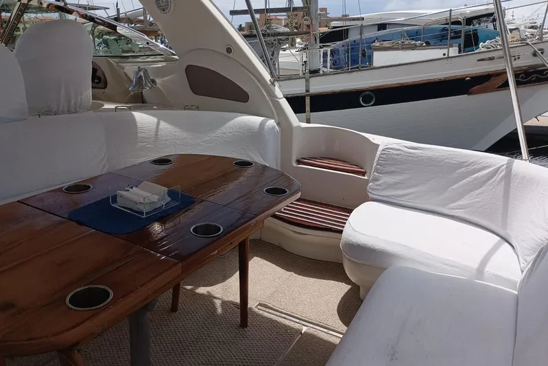 2000 Sea Ray 460 Sundancer @ Ixtapa Yacht Photos Pics Interior of 2000 Sea Ray 460 Sundancer yacht with wooden table and white seating.