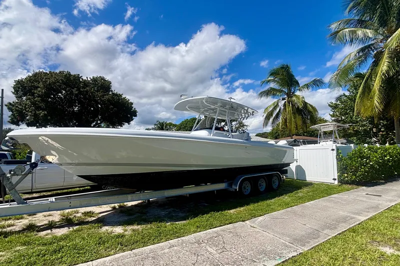  Yacht Photos Pics 2008 Intrepid 327 Center Console boat on trailer, surrounded by palm trees and blue sky.