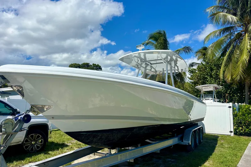  Yacht Photos Pics 2008 Intrepid 327 Center Console boat on trailer, surrounded by palm trees and blue sky.