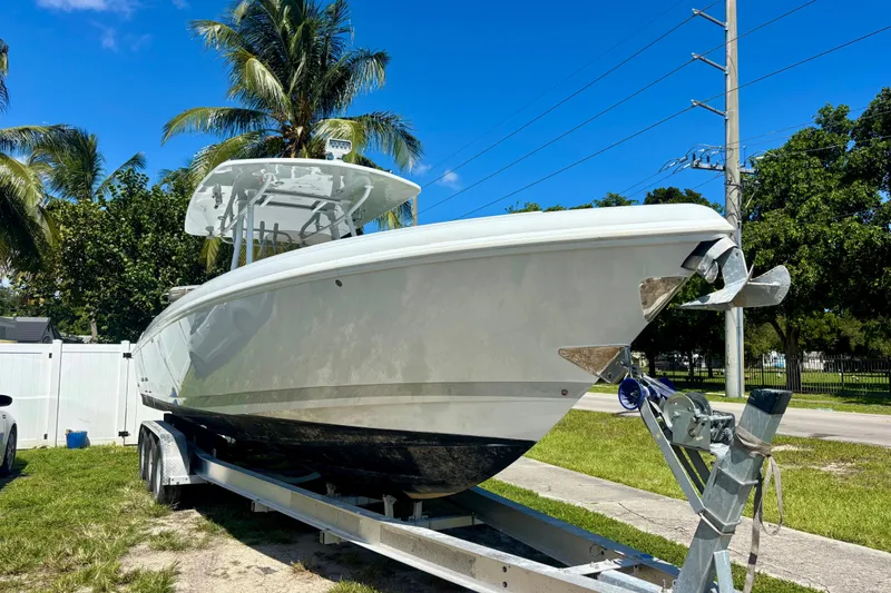  Yacht Photos Pics 2008 Intrepid 327 Center Console boat on trailer, surrounded by palm trees.