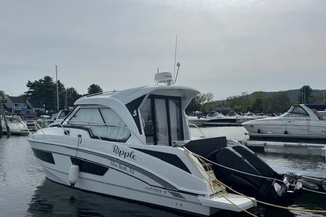  Yacht Photos Pics 2024 Beneteau Antares 9 boat docked in a marina, side view.