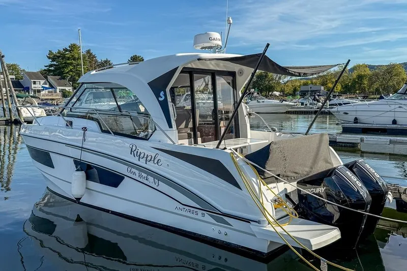  Yacht Photos Pics 2024 Beneteau Antares 9 boat docked in a marina, featuring twin Mercury engines.