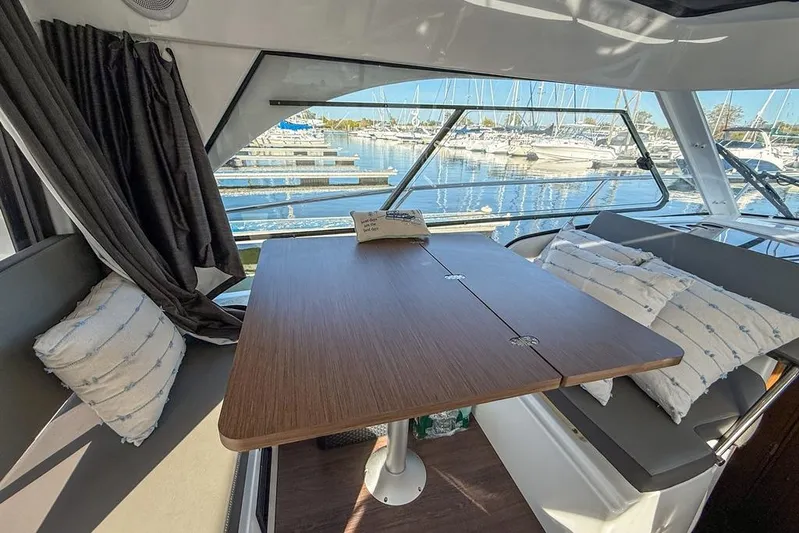  Yacht Photos Pics Interior of 2024 Beneteau Antares 9 with table and marina view.