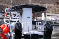 Olbap TR12 Open 2025 boat docked, featuring dual outboard motors and safety equipment.