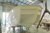 2025 Olbap TR12 Open boat hull in a workshop setting.