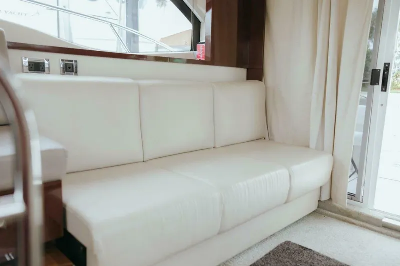 The Green Squirrel Yacht Photos Pics Interior of 2010 Sea Ray 390 Sedan Bridge with white leather sofa and sliding glass door.