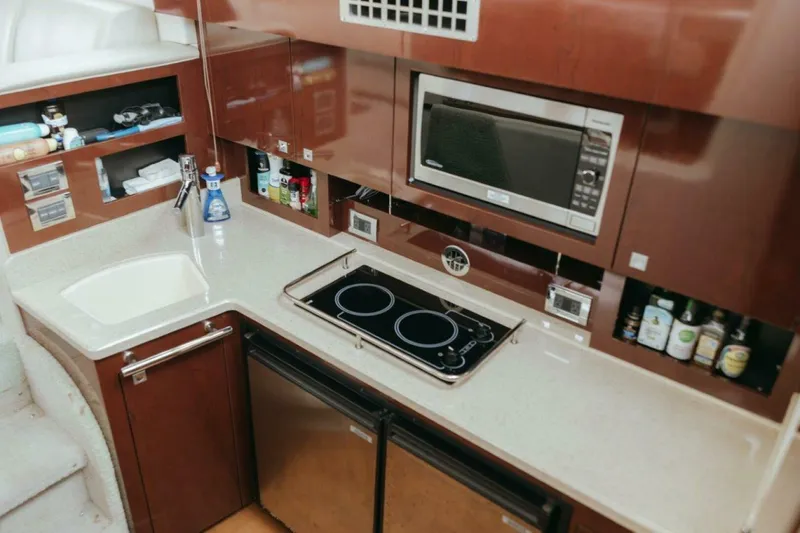 The Green Squirrel Yacht Photos Pics Modern kitchen in 2010 Sea Ray 390 Sedan Bridge yacht with stove, microwave, and sink.