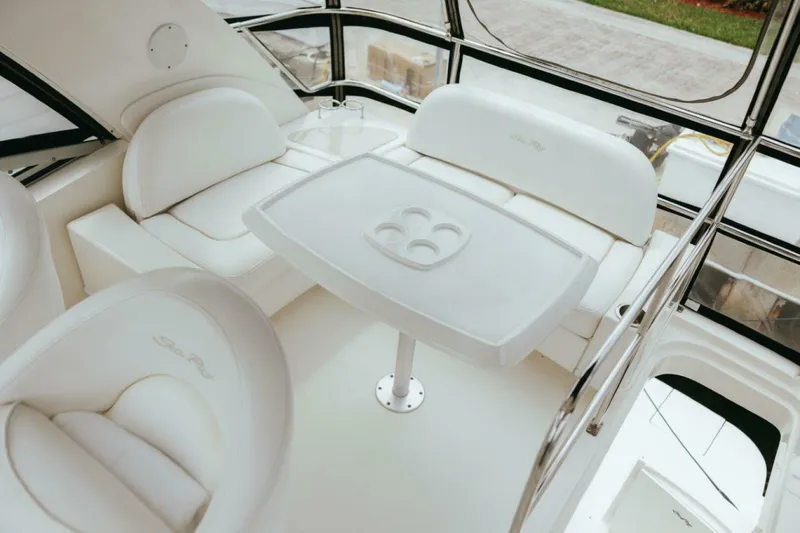 The Green Squirrel Yacht Photos Pics 2010 Sea Ray 390 Sedan Bridge interior with white seating and table.