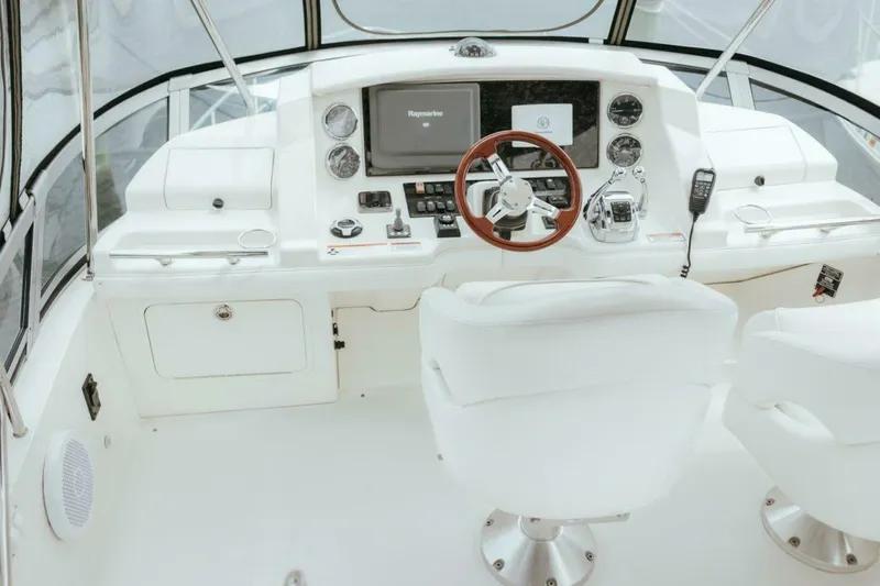 The Green Squirrel Yacht Photos Pics Helm of 2010 Sea Ray 390 Sedan Bridge with modern controls and white seating.