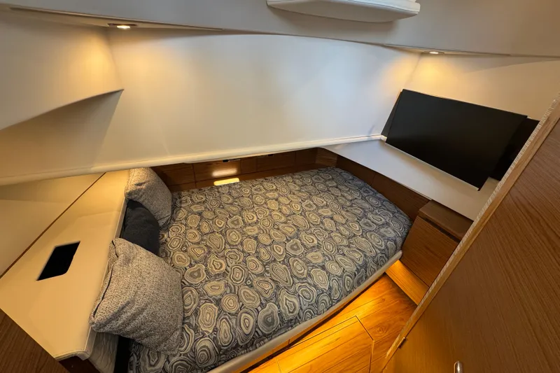  Yacht Photos Pics Luxurious cabin interior of 2025 Tiara Yachts 38 LS with cozy bedding and modern lighting.