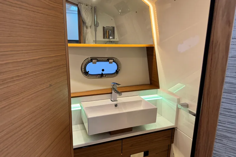  Yacht Photos Pics Luxurious bathroom interior of 2025 Tiara Yachts 38 LS with modern sink and porthole window.