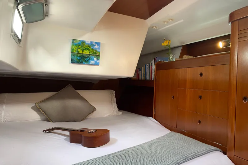 Unbound Yacht Photos Pics Cozy cabin interior of 2001 Beneteau First 47.7 yacht with guitar and books.