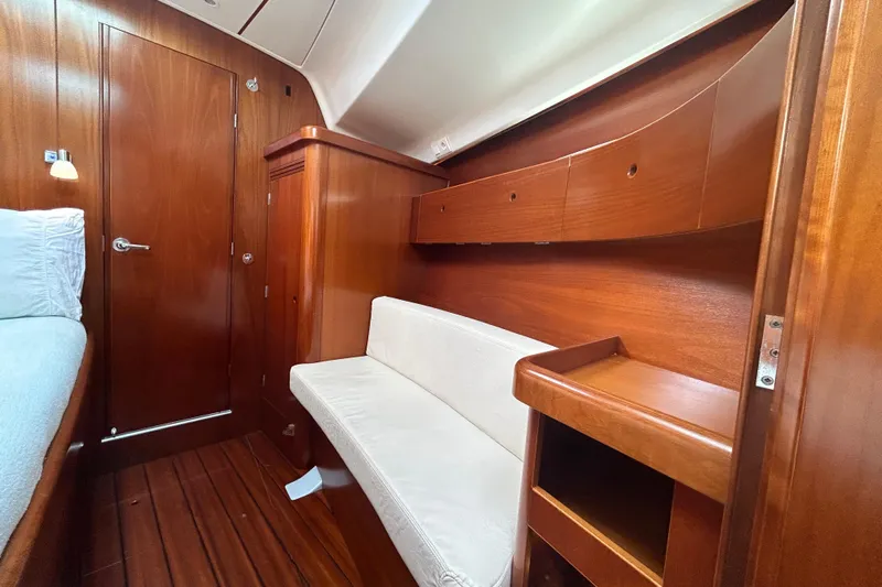 Unbound Yacht Photos Pics Cozy cabin interior of 2001 Beneteau First 47.7 yacht with wooden finish and seating.