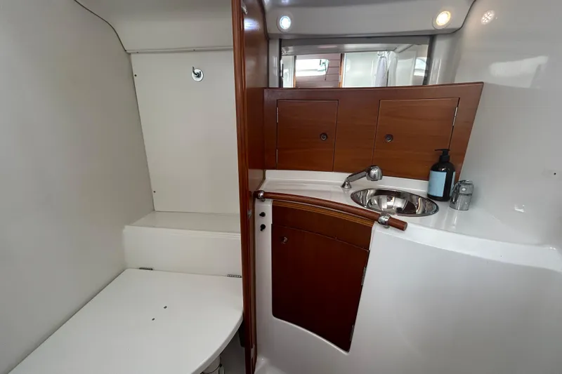 Unbound Yacht Photos Pics Beneteau First 47.7 2001 yacht bathroom with wooden cabinetry and stainless steel sink.