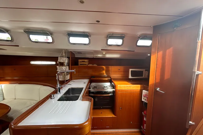 Unbound Yacht Photos Pics Luxurious interior of 2001 Beneteau First 47.7 yacht with modern kitchen amenities.