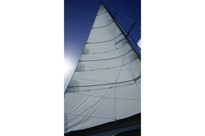 Unbound Yacht Photos Pics Sail of a 2001 Beneteau First 47.7 yacht against a clear blue sky.