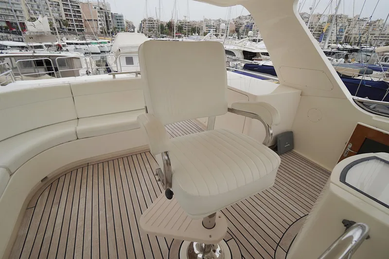 Defly Yacht Photos Pics Luxury yacht Marlow 61E, 2009 model, featuring elegant seating and teak deck in marina setting.