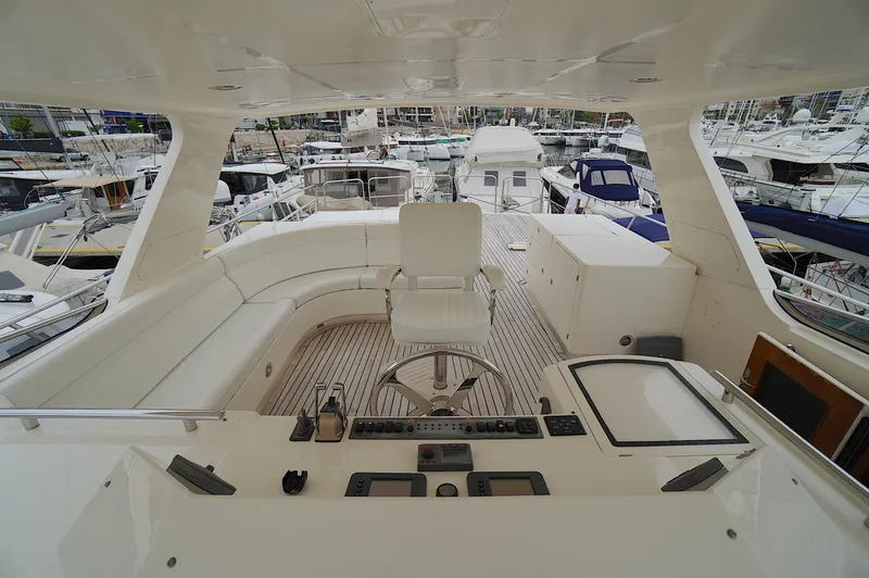 Defly Yacht Photos Pics Luxurious 2009 Marlow 61E yacht deck with helm, seating, and marina view.