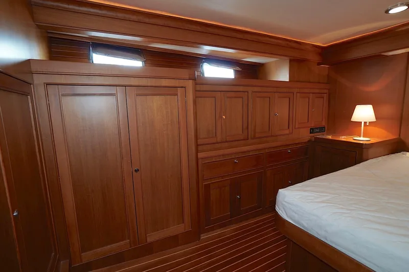 Defly Yacht Photos Pics Luxurious wooden cabin interior of 2009 Marlow 61E yacht with bed and lamp.