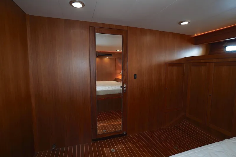 Defly Yacht Photos Pics Luxurious wooden interior of 2009 Marlow 61E yacht cabin with mirror and ambient lighting.