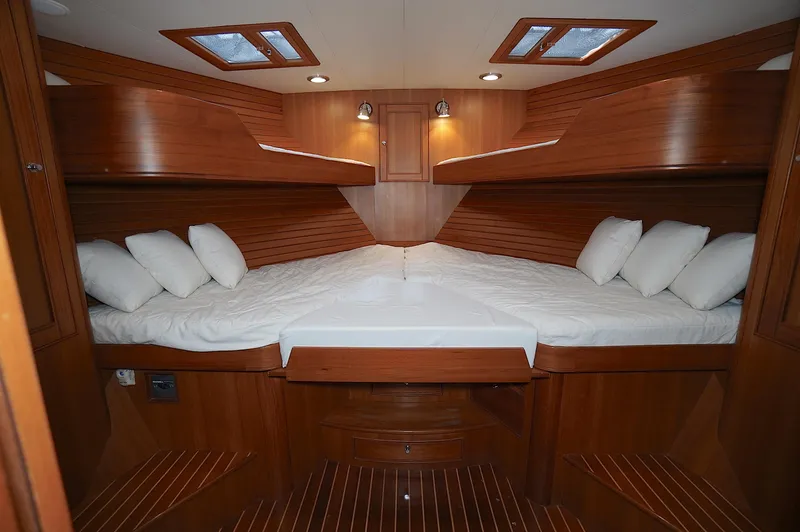 Defly Yacht Photos Pics Luxurious cabin interior of 2009 Marlow 61E yacht with wooden finish and cozy bedding.