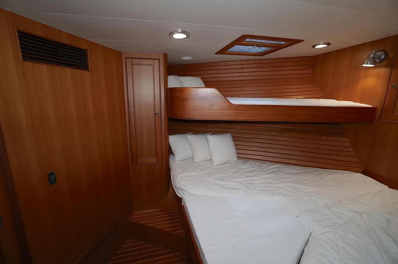 Defly Yacht Photos Pics Luxurious cabin interior of 2009 Marlow 61E yacht with wooden finishes and cozy bedding.