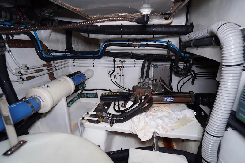 Defly Yacht Photos Pics Engine room of a 2009 Marlow 61E yacht, featuring pipes and mechanical components.