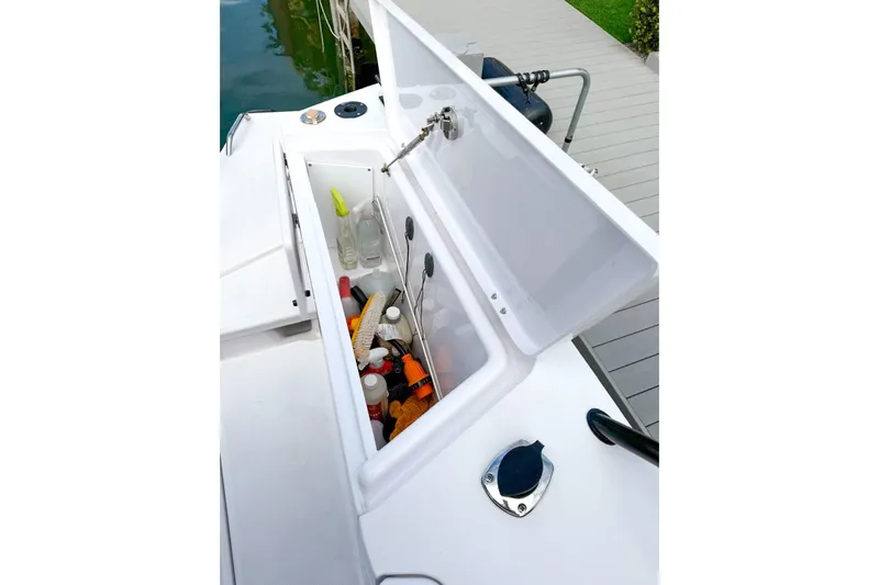  Yacht Photos Pics Storage compartment on 2023 Axopar 37 XC Cross Cabin, filled with cleaning supplies.