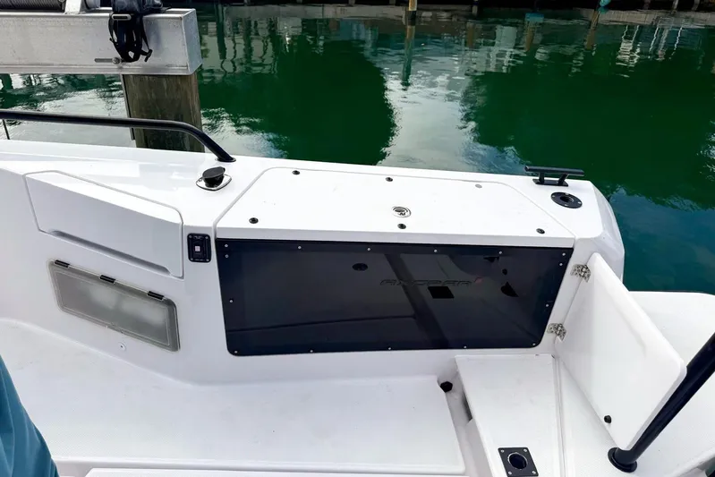  Yacht Photos Pics 2023 Axopar 37 XC Cross Cabin boat deck with storage compartment and railing.