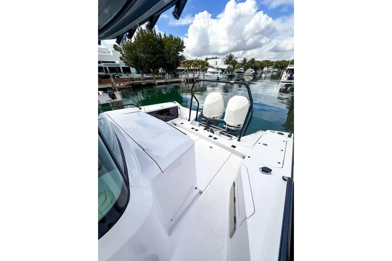  Yacht Photos Pics 2023 Axopar 37 XC Cross Cabin boat docked in a scenic marina.